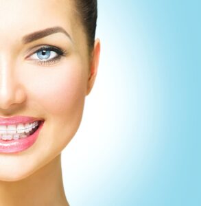 Smiling patient with clear braces showing results of modern orthodontics treatment focused on comfort